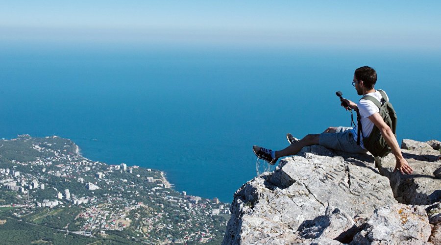 Турист фотографируется на вершине горы Ай-Петри в Крыму