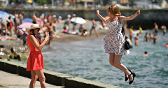 Девушки фотографируются на набережной Ялты