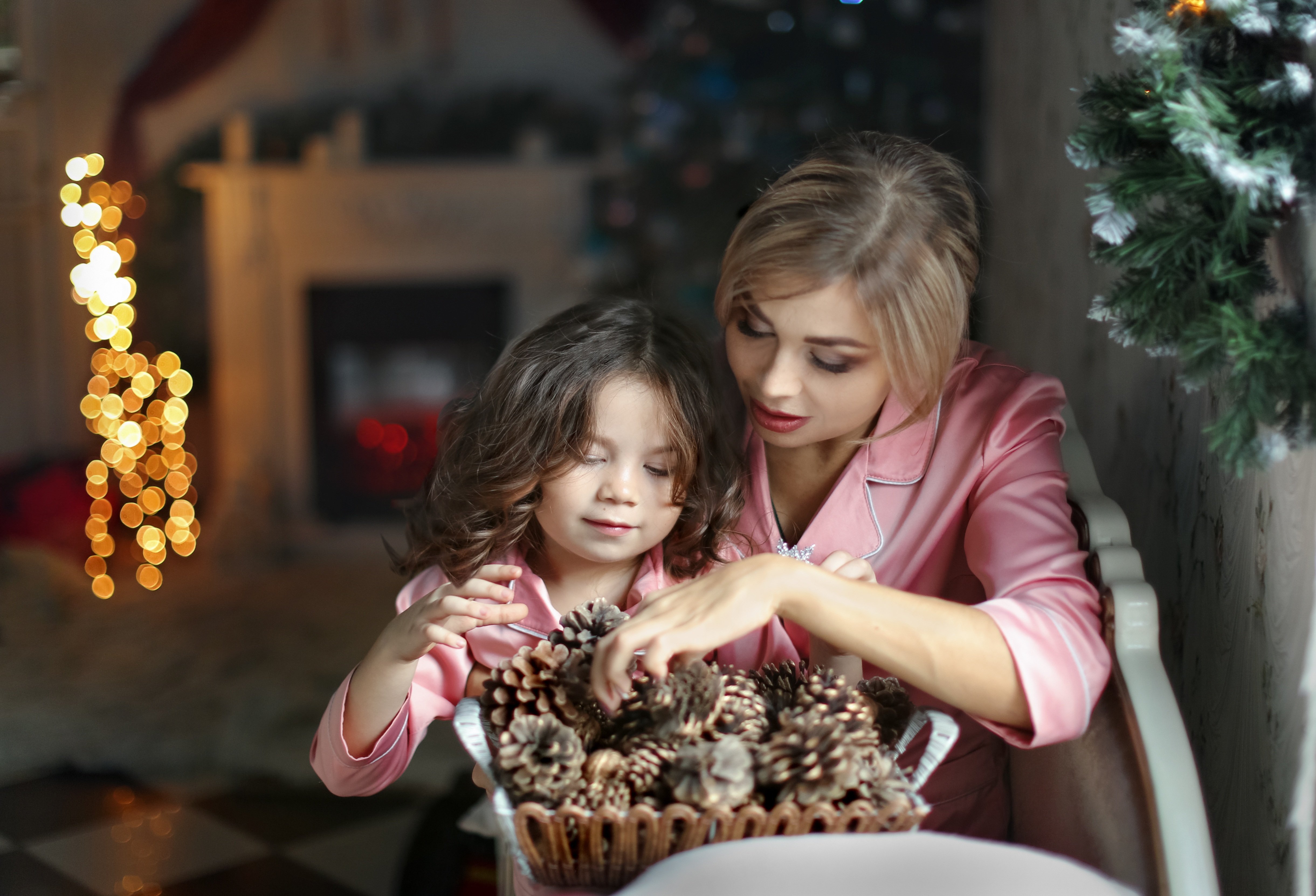 Женщина с ребенком готовят новогоднюю композицию для дома