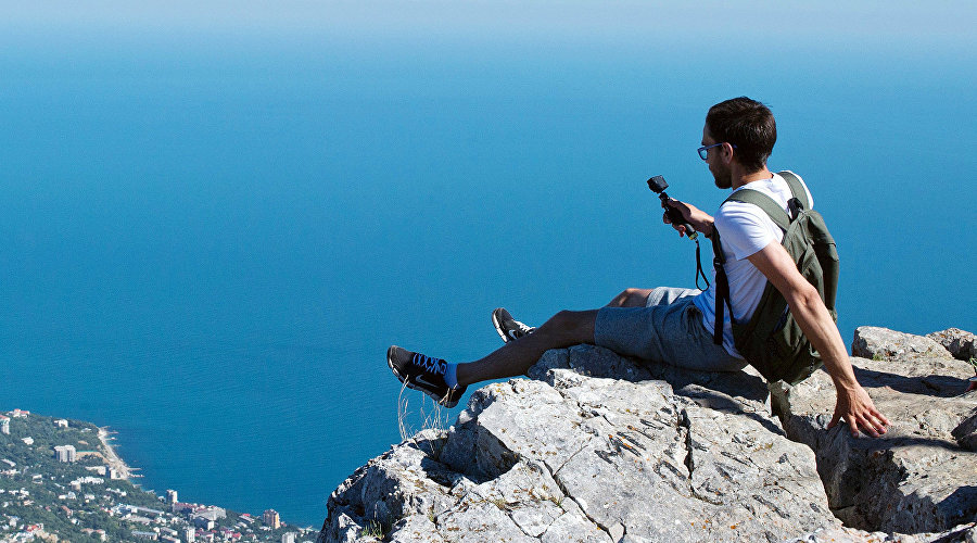 Турист фотографируется на вершине горы Ай-Петри в Крыму