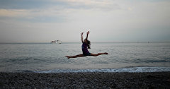 Девушка-гимнастка на берегу Черного моря