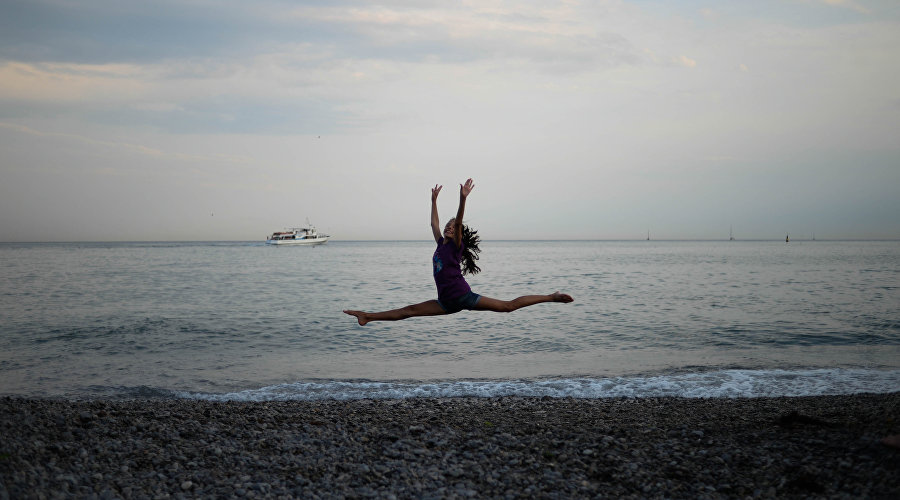 Девушка-гимнастка на берегу Черного моря