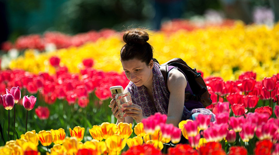 Посетительница фотографирует цветы на открытии выставки «Парад тюльпанов» в Никитском ботаническом саду в Крыму