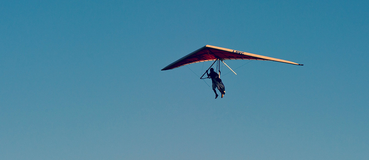 Участник фестиваля «Восходящий поток» летит на дельтаплане с горы Клементьева под Коктебелем в Крыму