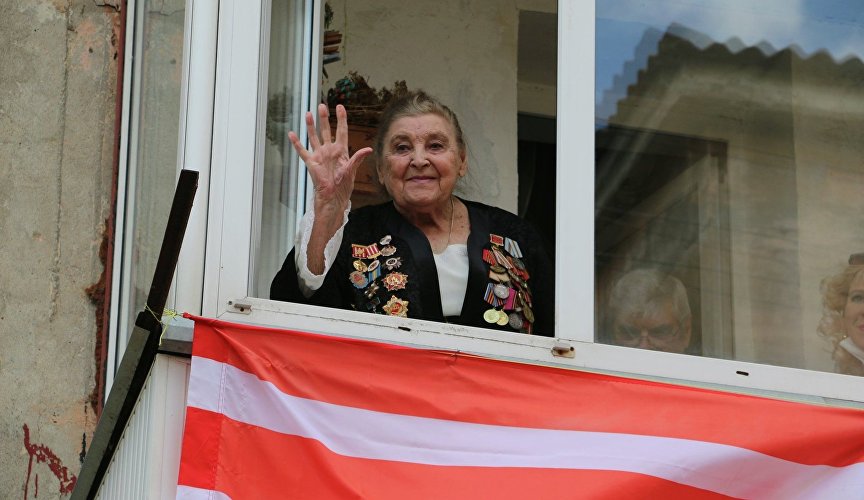 Ветеран слушает концерт на балконе своего дома в Керчи