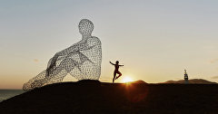 Девушка возле скульптуры «Человек, смотрящий в море»