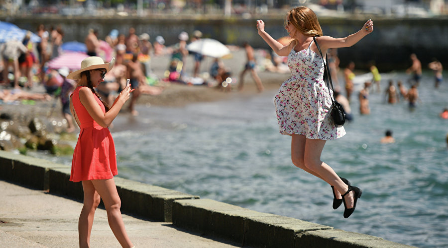 Девушки фотографируются на набережной Ялты