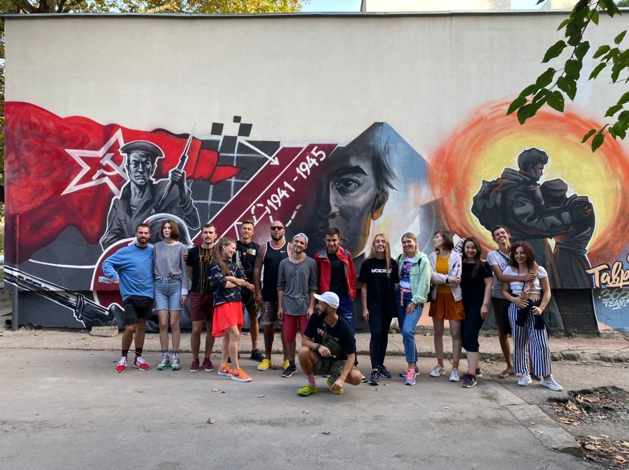 Участники форума &amp;laquo;Таврида&amp;raquo; возле стены с граффити в Симферополе