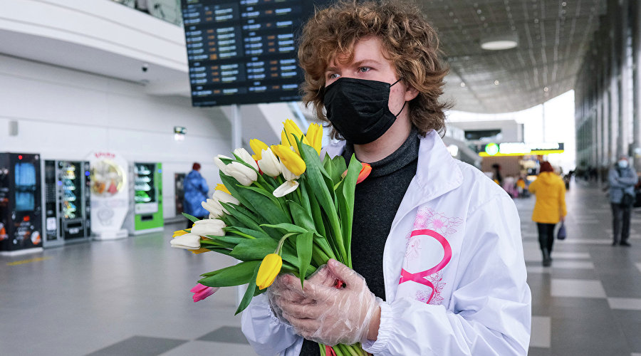 Волонтер с цветами в аэропорту Симферополь