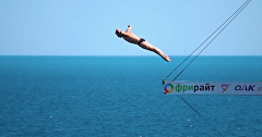 Участник Международного Кубка мира по клифф-дайвингу в Симеизе выполняет прыжок со скалы Дива
