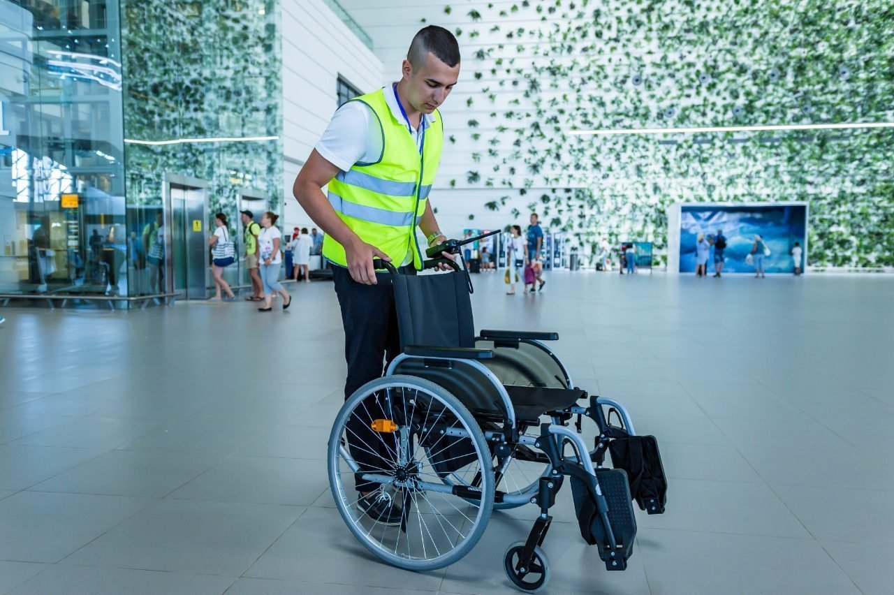 Сотрудник аэропорта Симферополь готовит инвалидное кресло