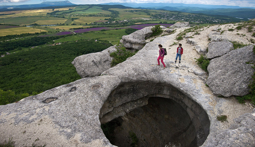 Туристы у провала в скале урочища Таш-Джарган в Симферопольском районе Крыма
