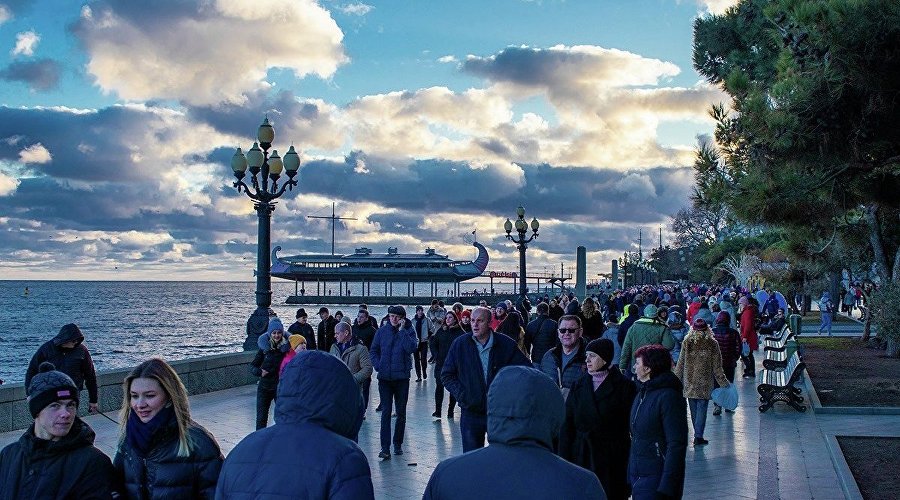 Люди гуляют на набережной Ялты в январе