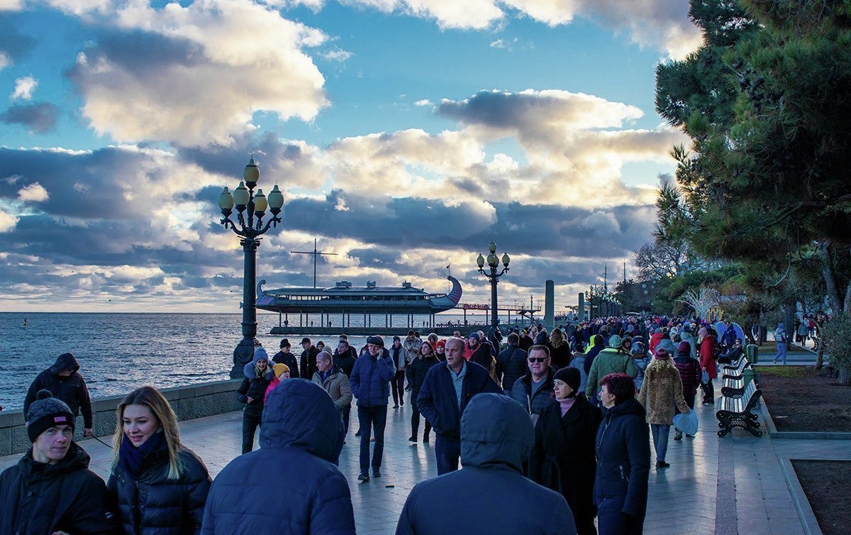 Люди гуляют на набережной Ялты в январе