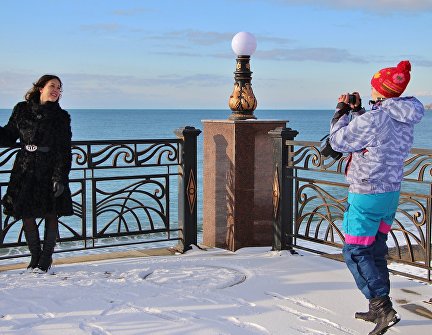 Туристы фотографируются на набережной Судака