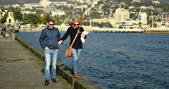 Пара гуляет по набережной Ялты