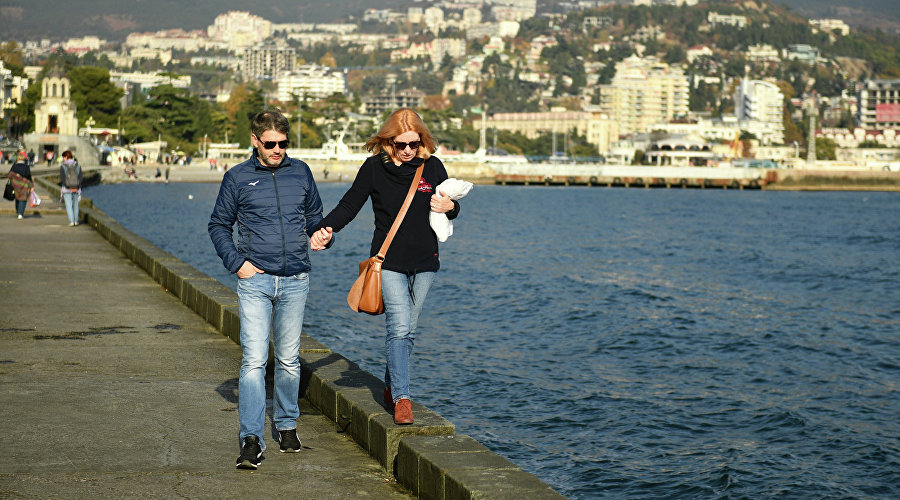 Пара гуляет по набережной Ялты