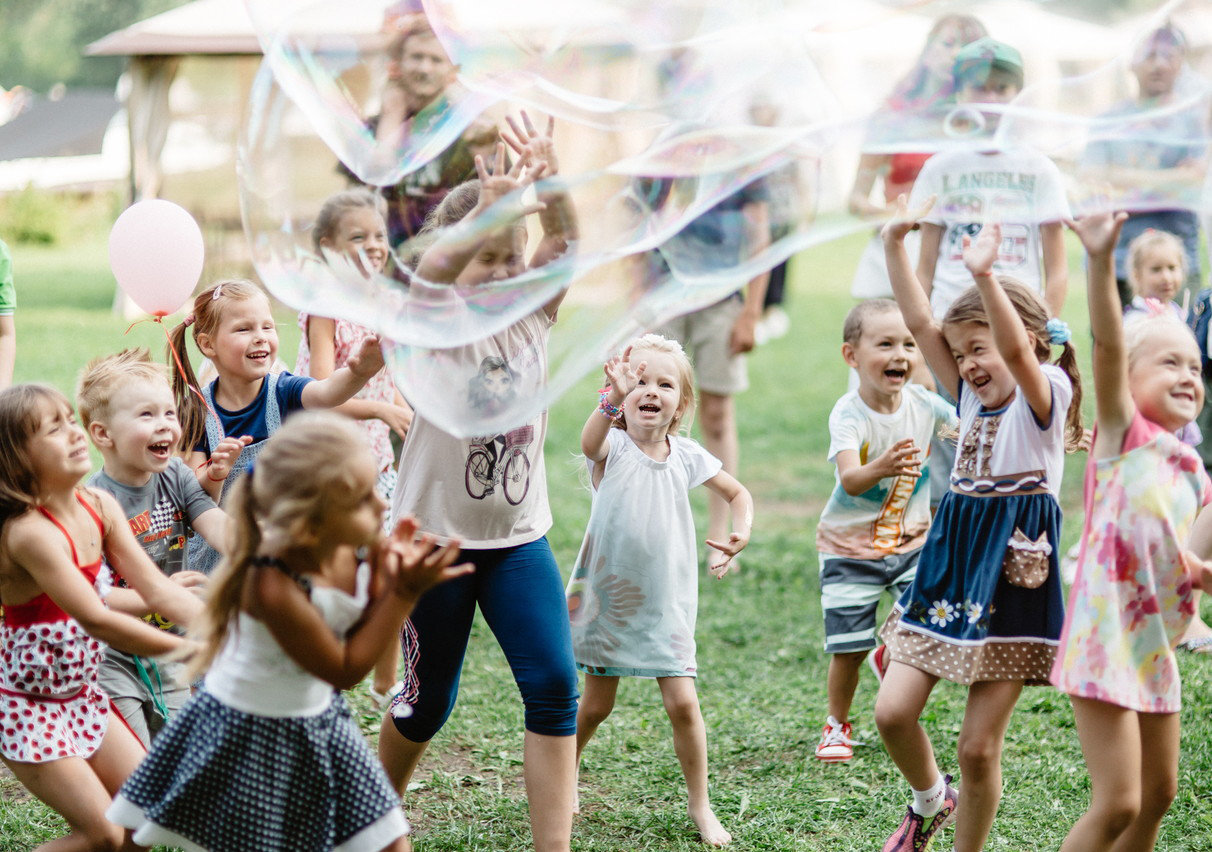 Дети играют с мыльными пузырями на фестивале
